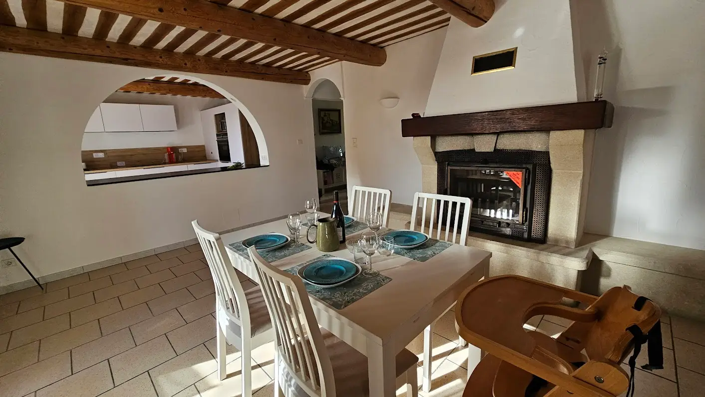 The living room table in front of the fireplace, beneath the beamed ceiling
