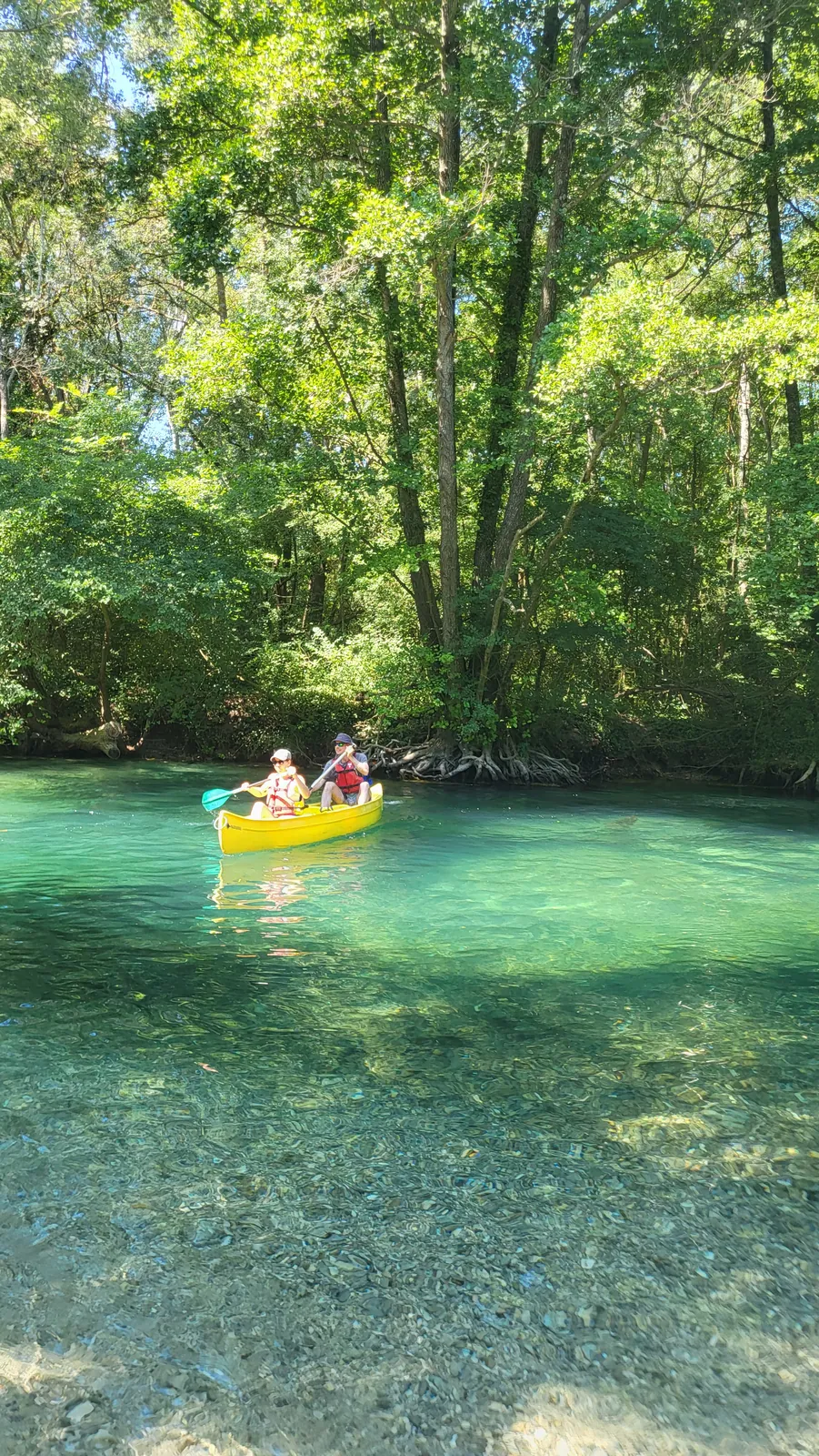 A yellow canoe on the turquoise water of the Sorgue